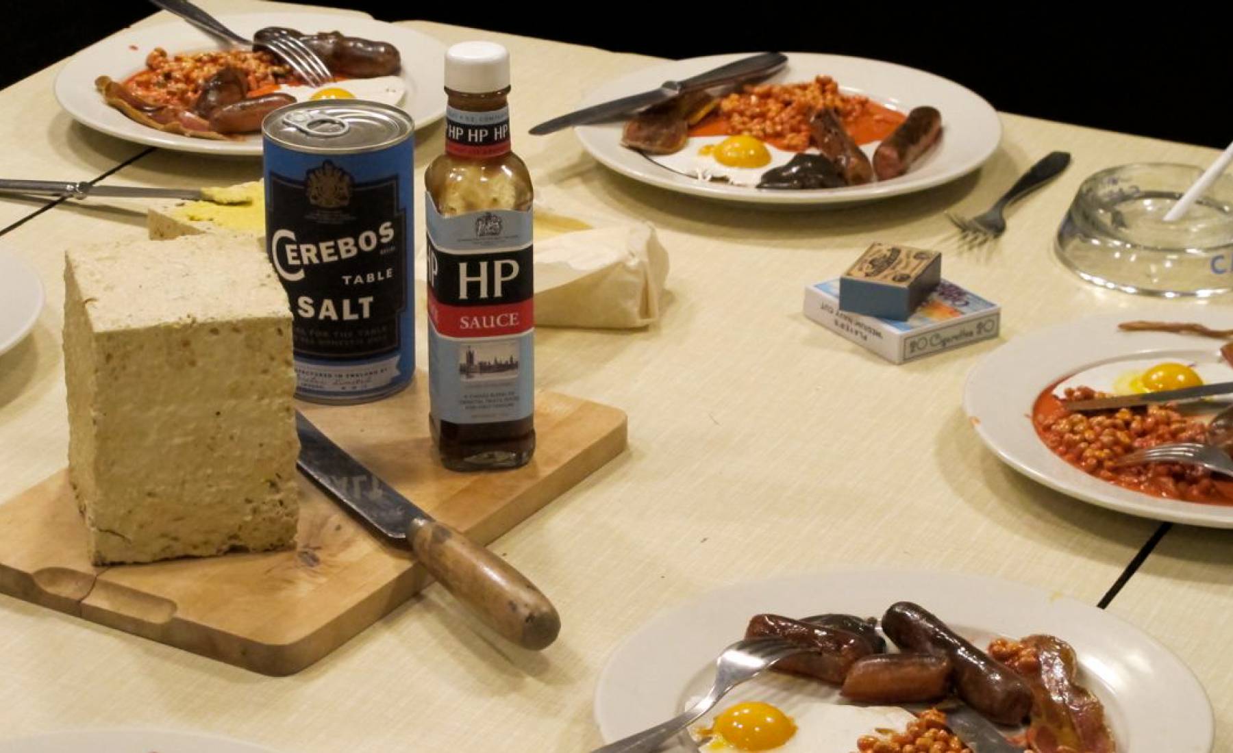 submarine realistic fake food, fried breakfasts on a table.1960's. bread, sausages, eggs, hp sauce, baked beans